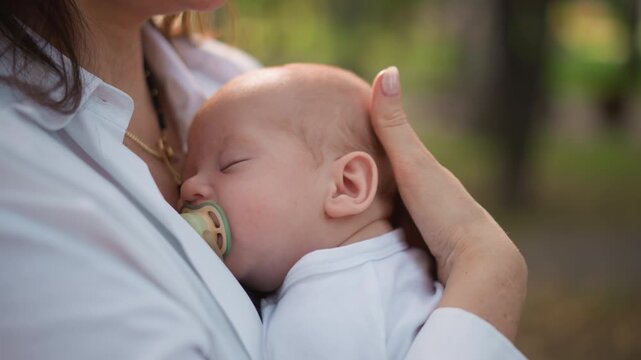Peaceful caretaker comforts young child. Gentle caregiver lovingly holds infant peacefully. Serene nurturing scene where gentle mother gently holds her sleeping infant in quiet surroundings
