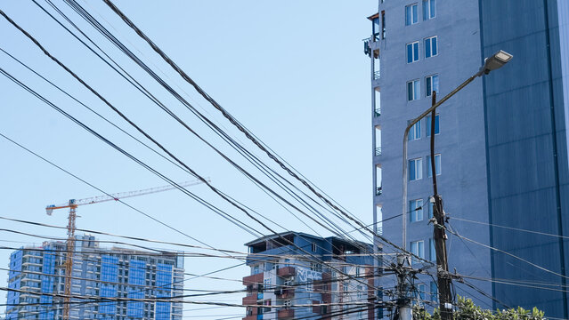 Urban skyline with power lines and modern buildings under clear blue sky
