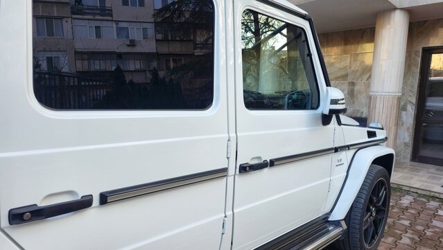 Varna. Bulgaria. 05.04.2026 side profile of luxury suv with black alloy wheels and strong body lines parked near residential building in calm daylight environment
