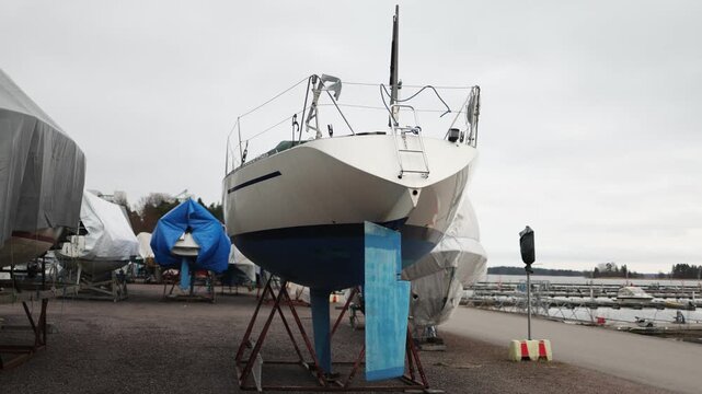 Boats stored on land covered with tarps dry dock storage outdoor boat yard maintenance and winter protection concept nautical industry and marine equipment
