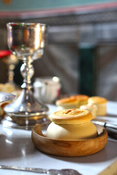 Church utensils for communion in an Orthodox church: chalice, prosphora and liturgical bread on the altar, sacred atmosphere of worship. Concept of Orthodoxy.

