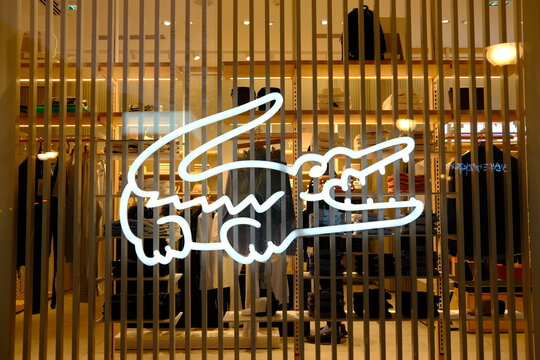 Belgrade, Serbia &ndash; April 7, 2026 &ndash; Lacoste store neon crocodile logo sign glowing on city center facade