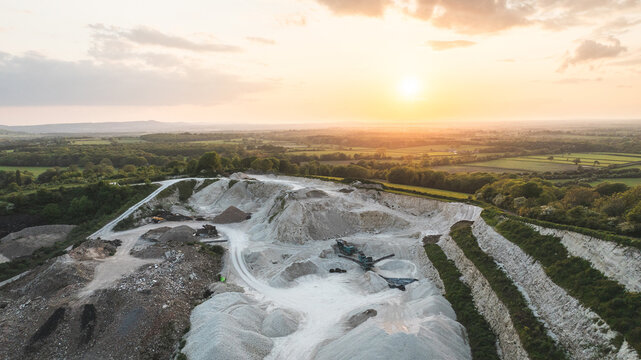 Aerial view of a quarry at sunset with golden light illuminating the landscape