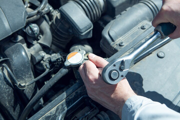 Obraz premium Auto mechanic using a wrench to check the oil level of the car