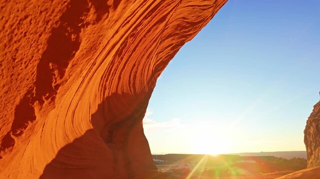 Biidi Arch spans across desert landscape under warm golden sunset light near Page Arizona