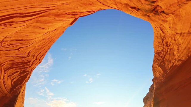 Biidi Arch spans across desert landscape under warm golden sunset light near Page Arizona