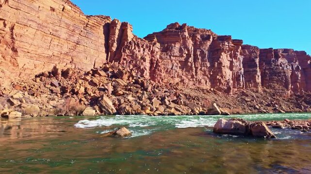 View of Colorado River shoreline flowing through Marble Canyon with desert cliffs and layered landscape