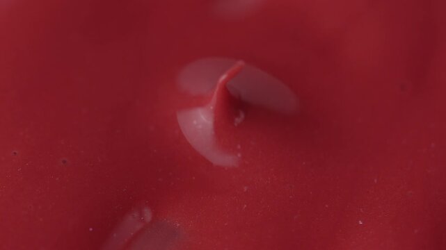 Macro shot of glossy red cosmetic lipstick texture applicator