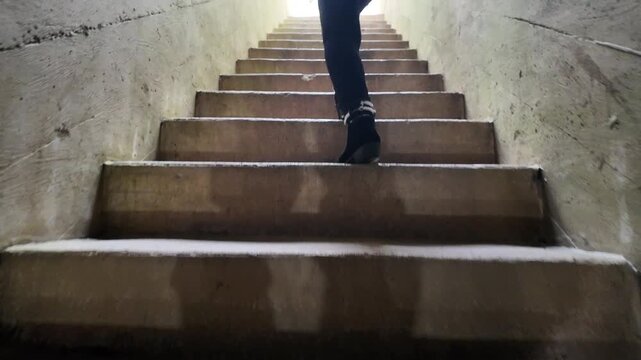Female Walking up Stone Steps Leading out of Cave Cavern