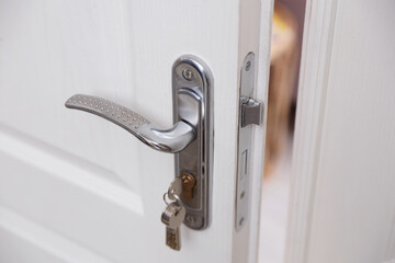 Naklejka premium Door with keys and metal handle indoors, closeup