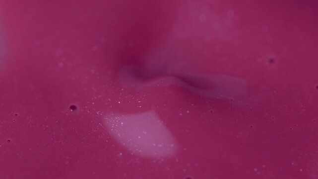 Macro shot of glossy pink cosmetic lipstick texture applicator