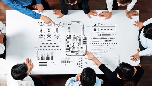A diverse business team engages in a collaborative meeting focused on cybersecurity, analyzing data visuals, and strategizing solutions to enhance digital protection. Raster