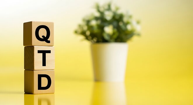 Qtd letters printed on wooden blocks stacked vertically representing quarter to date business metric with business intelligence