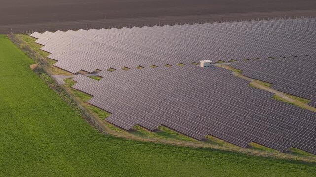 Aerial Shot of Solar Energy Farm Stretching Across Landscape at Sunset