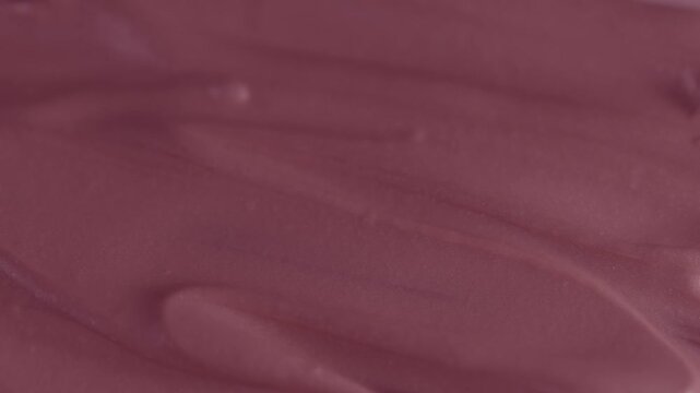 Macro shot of glossy pink cosmetic lipstick texture applicator