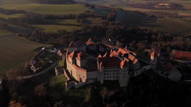 Drohnenansicht der Burg Harburg im Noerdlinger Ries, Bayern, Deutschland hoch ueber dem Woernitz Fluss an einem sonnigen aber kalten Tag.