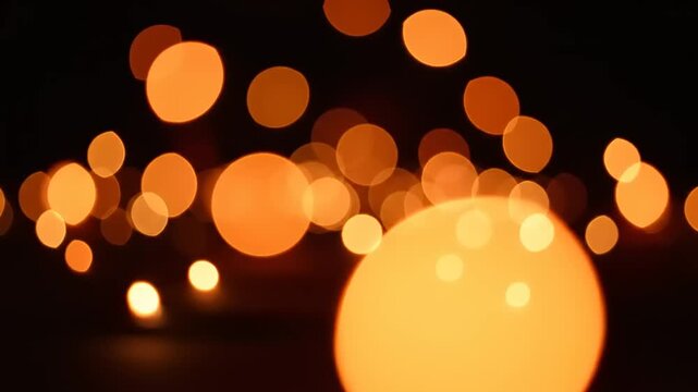 Bright orange bokeh lights create a warm and festive atmosphere in this vibrant scene