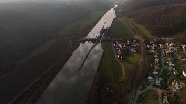 Aerial drone view of Schleuse Kelheim on Main Danube Canal Germany. Autumn sunset panorama with river, hydropower plant, ship lock and surrounding village landscape. Wasserkraftwerk Kelheim