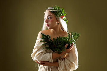 Obraz premium Beautiful elf girl with floral decor on dark olive background