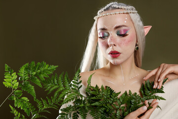 Obraz premium Beautiful elf girl with floral decor on dark olive background