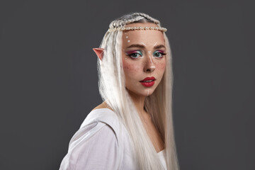 Obraz premium Beautiful girl dressed as elf on grey background