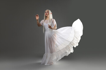 Obraz premium Beautiful girl dressed as elf on grey background