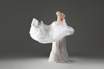 Obraz premium Beautiful girl dressed as elf on grey background