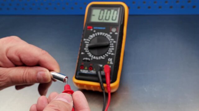 Measuring the voltage of alkaline batteries using a digital multimeter.