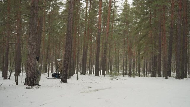 Snowy pine woods with parked atv and visible tire tracks, remote expedition pause with overcast sky, quiet forest clearing and rugged machine resting, crew break and trail navigation in cold landscape