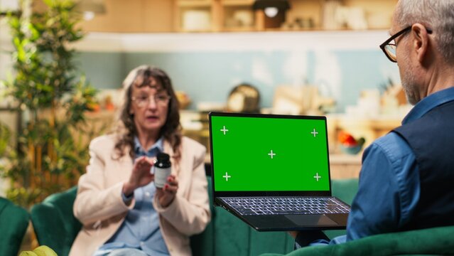 Isolated chroma key, aged woman, laptop in living room, retirement age, senior husband and wife enjoying quiet free time together. Old couple ensuring daily care with medicine for wellness.