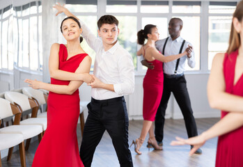 Fototapeta premium Couple of young guy and young woman dancing tango in studio