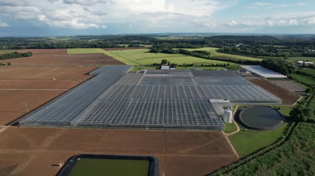 Large modern industrial greenhouses in flat landscape used for fruit and vegetable production captured as aerial panorama agriculture technology