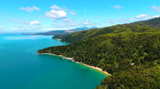 Aerial view of the stunning Abel Tasman coastline where turquoise waters meet lush green forests and sandy beaches, Abel Tasman National Park, New Zealand.