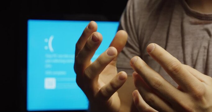 Close-up of hands expressing frustration in front of a computer error screen, symbolizing IT failure, system crash, and digital stress.