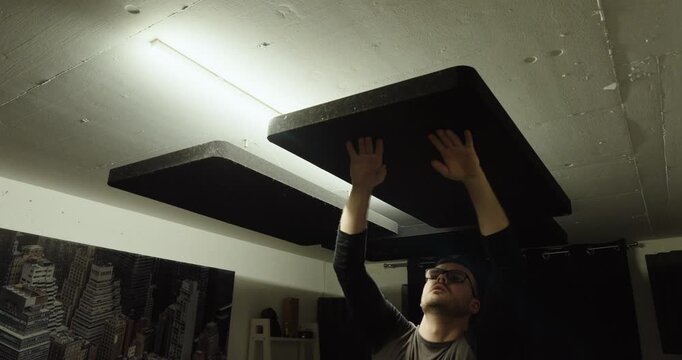 Man Testing Ceiling Soundproof Panels &ndash; Acoustic Insulation Installation Concept