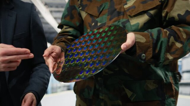 Close up of silicon wafer used by government to upgrade national security defense equipment. Engineer showing army officer semiconductor substrate optimizations to win chip war, camera A