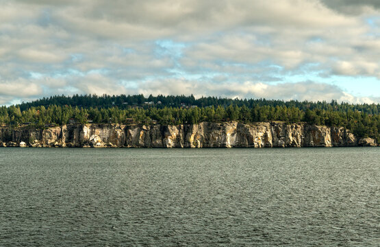 Canada, BC, Naniamo.  Homes and cottages along the ridge above the rocky shoreline of Vancouver Island