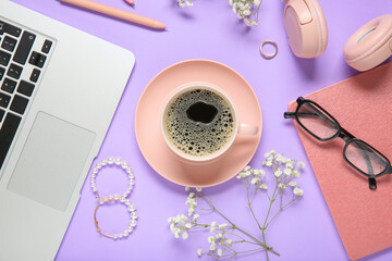 Cup of coffee with laptop, notebook, headphones, eyeglasses, jewelry and gypsophila flowers on...