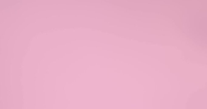 Little girl in swimsuit with inflatable ring waving on pink background