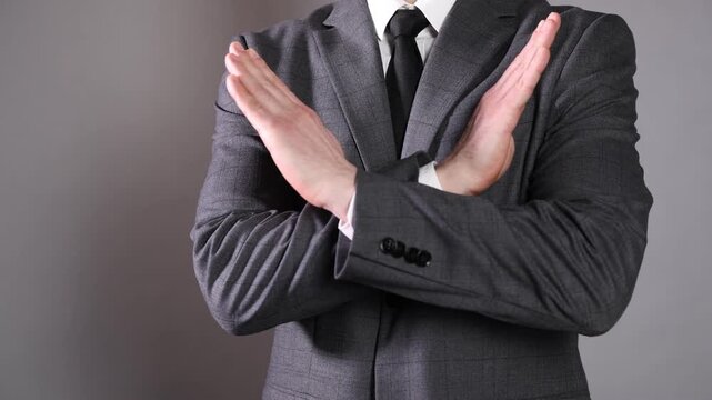 Businessman crossing arms expressing disagreement on grey background, closeup