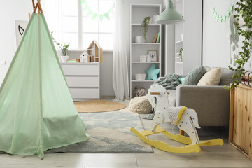 Interior of children's room with tent, sofa and rocking horse © Pixel-Shot