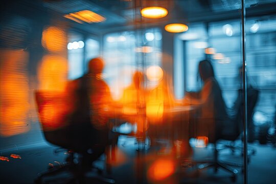 Abstract view of a blurred business meeting through glass, with orange and blue tones
