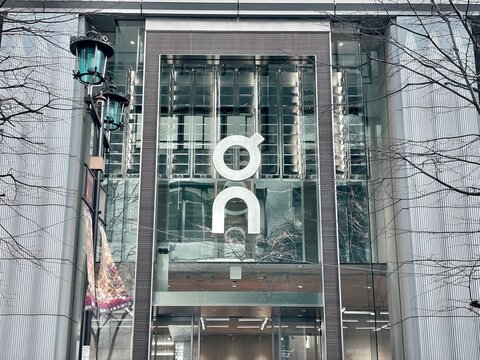 On Running flagship retail store facade featuring large white logo on glass exterior in the Ginza Namiki-dori luxury shopping district - Tokyo, Japan, January 25, 2024