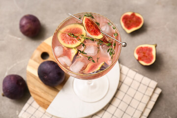 Glass of tasty fig lemonade on grey grunge background, closeup