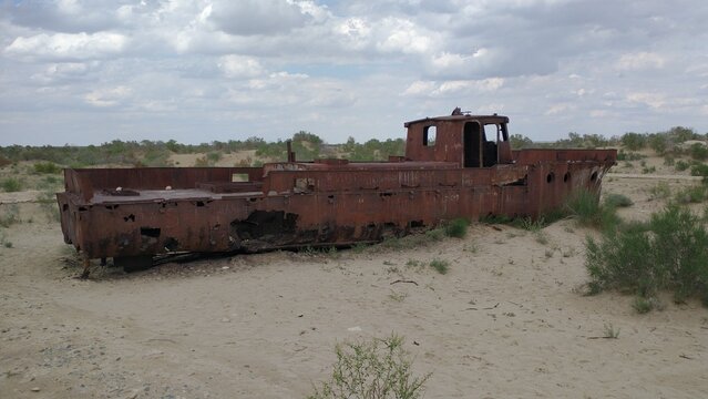 Abandoned rusty ship in the desert of the former Aral Sea, ecological disaster landscape in Moynaq, Uzbekistan.