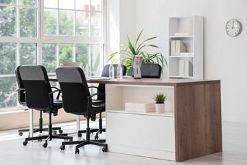 Fototapeta premium Interior of conference hall with desk, shelf unit and palm plant