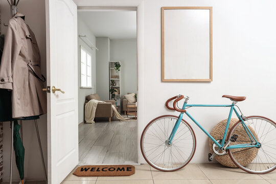 Interior of hallway with bicycle, blank frame and open door