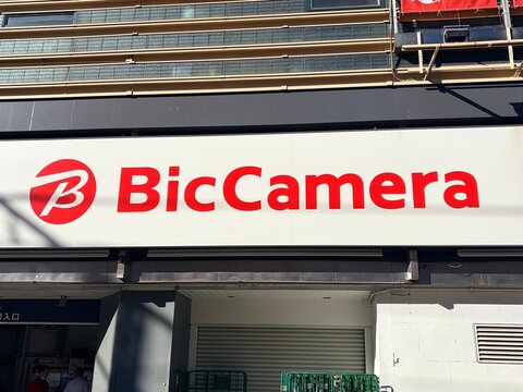 Bic Camera store exterior signage with large red logo on the side of a modern retail building on a sunny day in downtown Tokyo - Tokyo, Japan, October 15, 2024