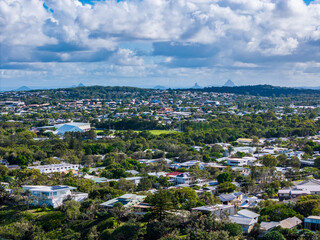 Fototapeta premium Panoramic View of a Lush Coastal Town on the Sunshine Coast, Queensland, with Glass House Mountains in the Distance