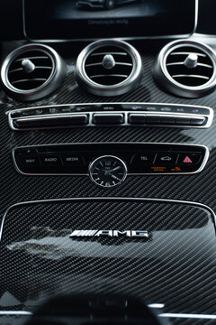 Mercedes AMG C63 carbon fiber center console logo and analog IWC watch, Luxury sportscar cabin details and controls